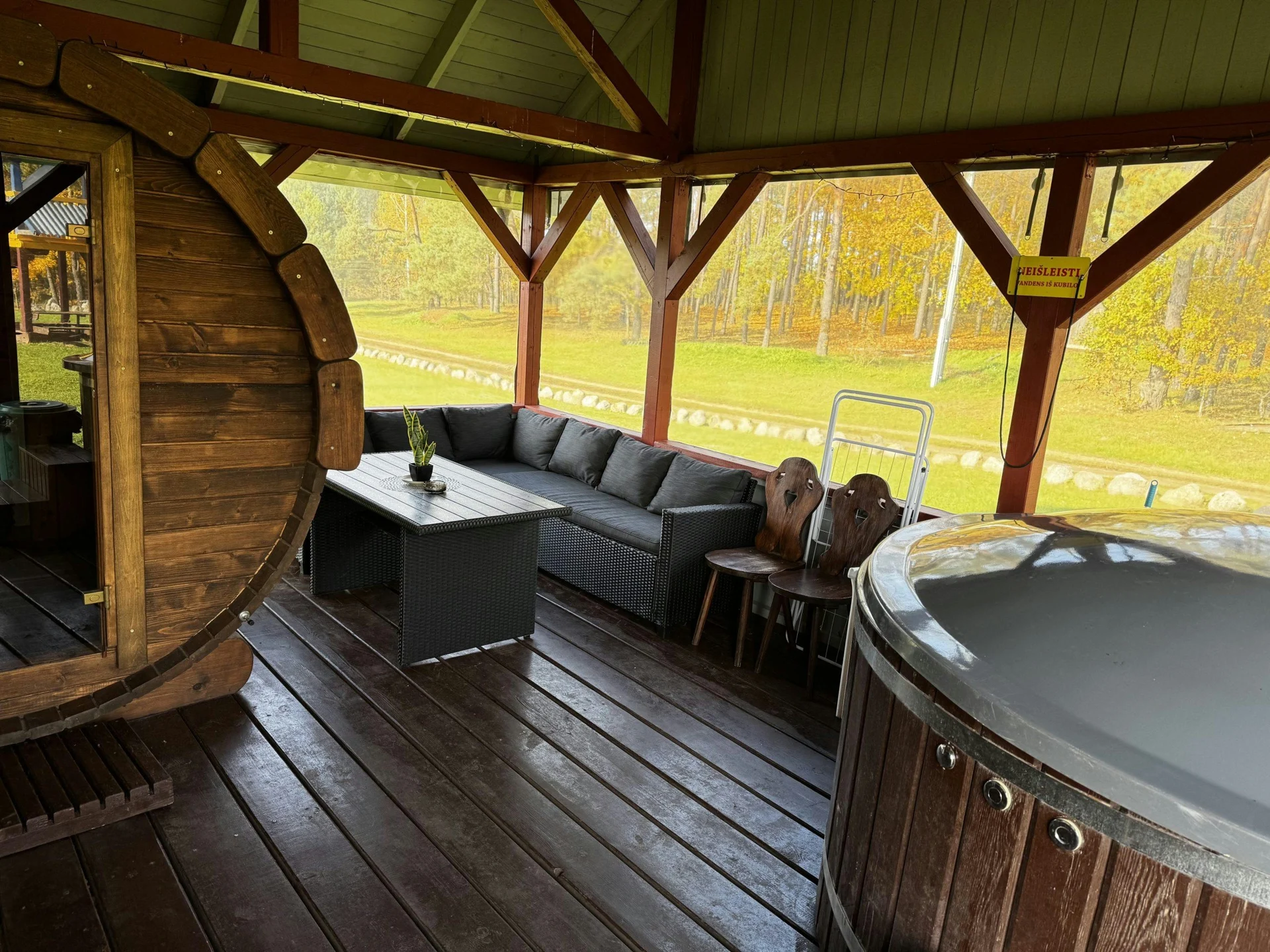 6 namelis – Medinė dengta terasa su apvalia pirtimi, pilka kampine sofa, stalu ir kubilu