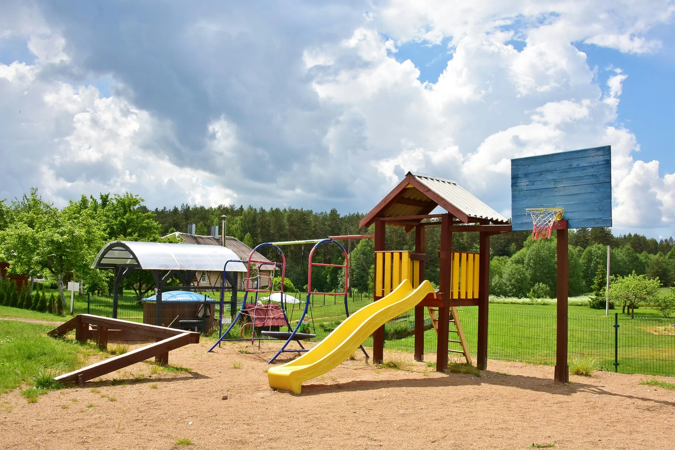 7A kotedžas – Smėlio žaidimų aikštelė su geltona čiuožykla, sūpynėmis ir krepšinio lenta